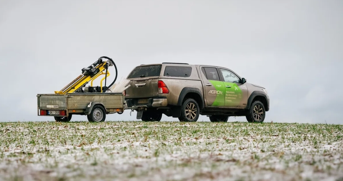 Lietuvos ūkio laukas ir ūkininkas, iliustruojantys anglies kreditų temą.